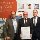 René Efler (l.) übergab die Auszeichnung an Beurer Geschäftsführer Georg Walkenbach (r.) und Vertriebsleiter Berthold Niehoff (M.).
