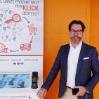 In seiner neuen Funktion bei Springlane besuchte Sven Möller die Messe EK Home und stellte sich infoboard.de vor dem neuen digitalen Kiosk-System zum Foto.