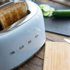 Der Toaster von Smeg bräunt große und kleine, dicke oder dünne Scheiben optimal. Er bietet sechs Röstgradstufen und zentriert das Brot automatisch in den Röstschächten.