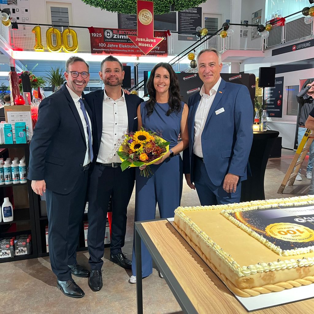 Martin Wolf (General Manager EK Home Electrical Appliances, EK Retail) und Christian Bichlmeier (Regionalleiter electroplus, EK Retail) gratulieren Bernd Zimmerly (Geschäftsführer, Zimmerly Elektro GmbH und Tanja Zimmerly (Prokuristin, Zimmerly Elektro GmbH) zum 100-jährigen Jubiläum von Elektrohaus Zimmerly.