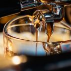 Close-up of espresso shot pouring from coffee machine in coffee shop