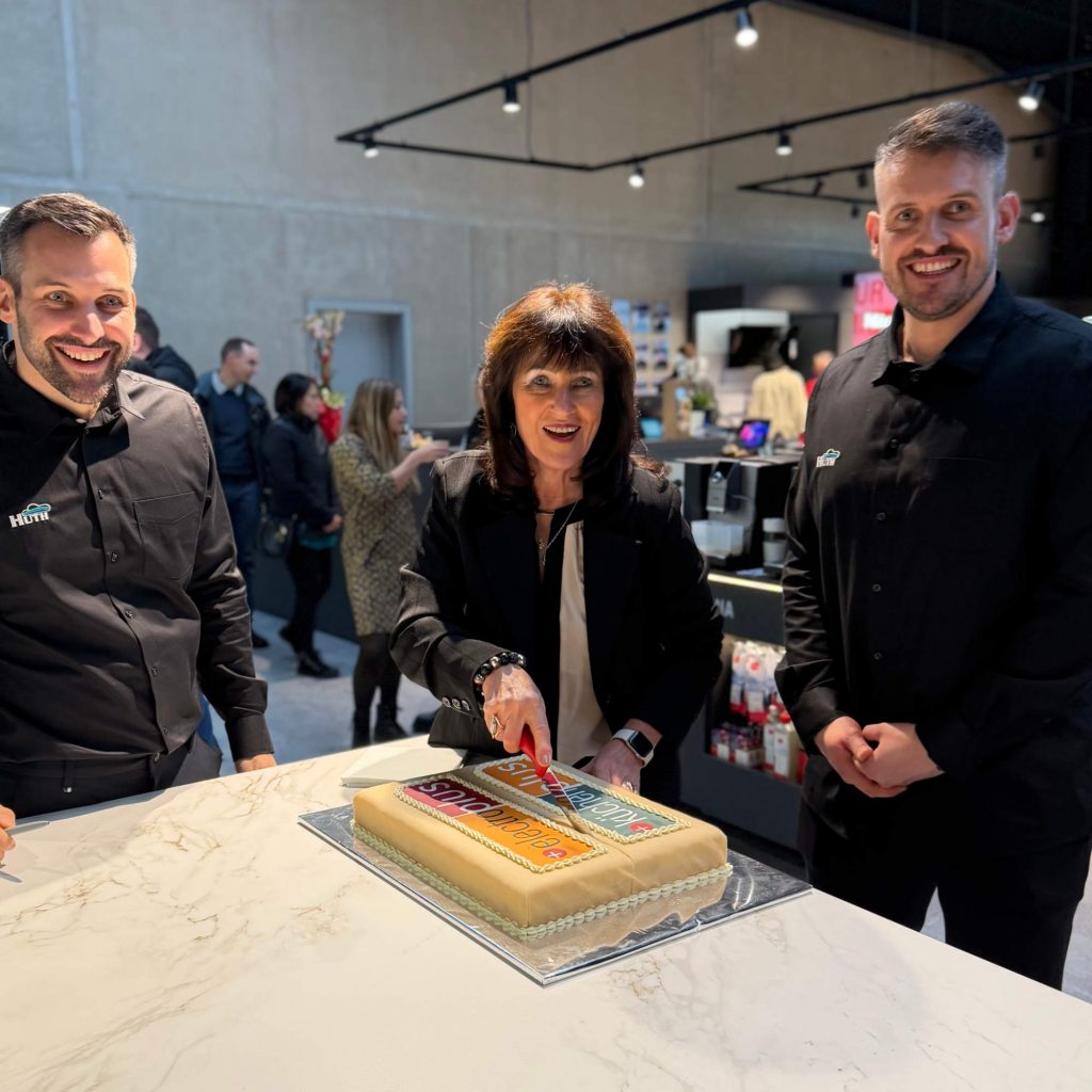 (v. l. ) Simon Huth (Geschäftsführer, Hausgeräte Huth), Klaudia Huth (Geschäftsführerin, Hausgeräte Huth) und Aljoscha Huth (Geschäftsführer, Hausgeräte Huth) schneiden zusammen die electroplus Torte zur Neueröffnung an.