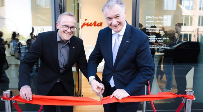 Jura-Chef Horst Nikolaus (r.) und Store-Leiter Kevin Sinclair schneiden das rote Band zur Eröffnung des neuen Jura-Stores in Hamburg durch.